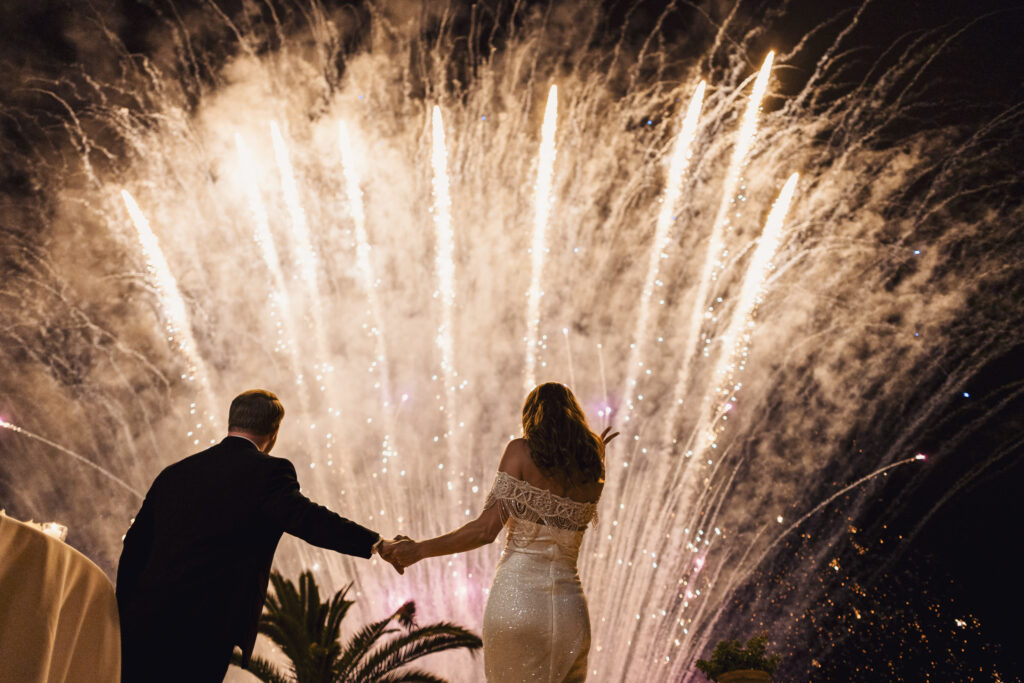Couple celebrating with fireworks during a destination wedding in Sicily